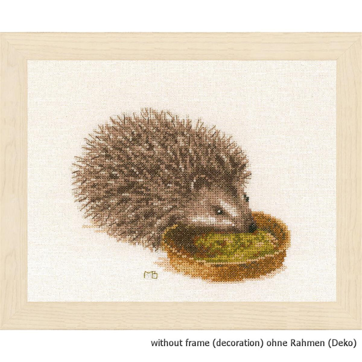 A cross-stitch illustration of a hedgehog on the edge of...