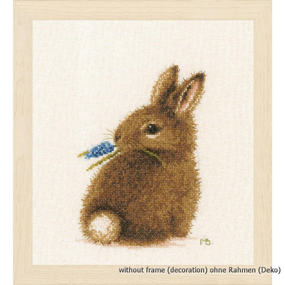 Cross stitch picture of a brown bunny sitting with its...