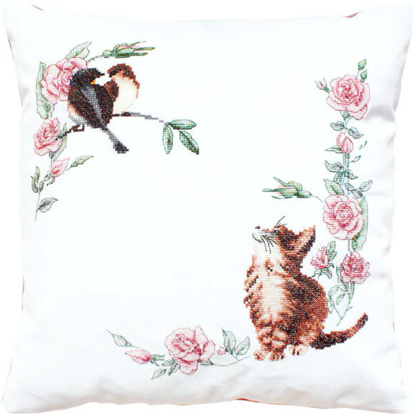 A white throw pillow with an enchanting cross-stitch pattern. The carefully designed Luca-s embroidery pack shows a kitten looking up at a bird sitting on a branch, surrounded by an arch of pink roses and green leaves.
