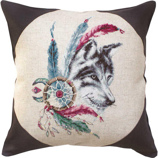 A decorative cushion features a woven design of a wolf-s head surrounded by bright feathers and a dreamcatcher with beads, reminiscent of a Luca-s embroidery pack. The image is centered in a round frame on a beige background, and the rest of the pillow is made of dark brown fabric.