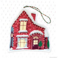 Een kruissteek ornament uit een Luca-s borduurpakket met een winters rood huis met sneeuw op het dak en de vensterbanken. Het huis heeft verlichte ramen, een groene struik bij de ingang en een lantaarnpaal. Aan de bovenkant is een gevlochten koordlus bevestigd om op te hangen. De achtergrond heeft een subtiel zuurstokpatroon.