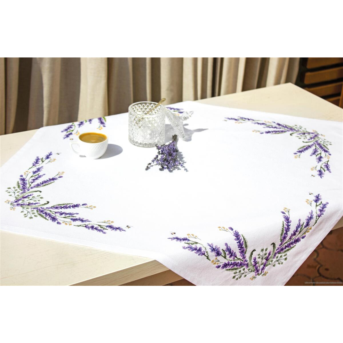 A white tablecloth with delicate purple floral...