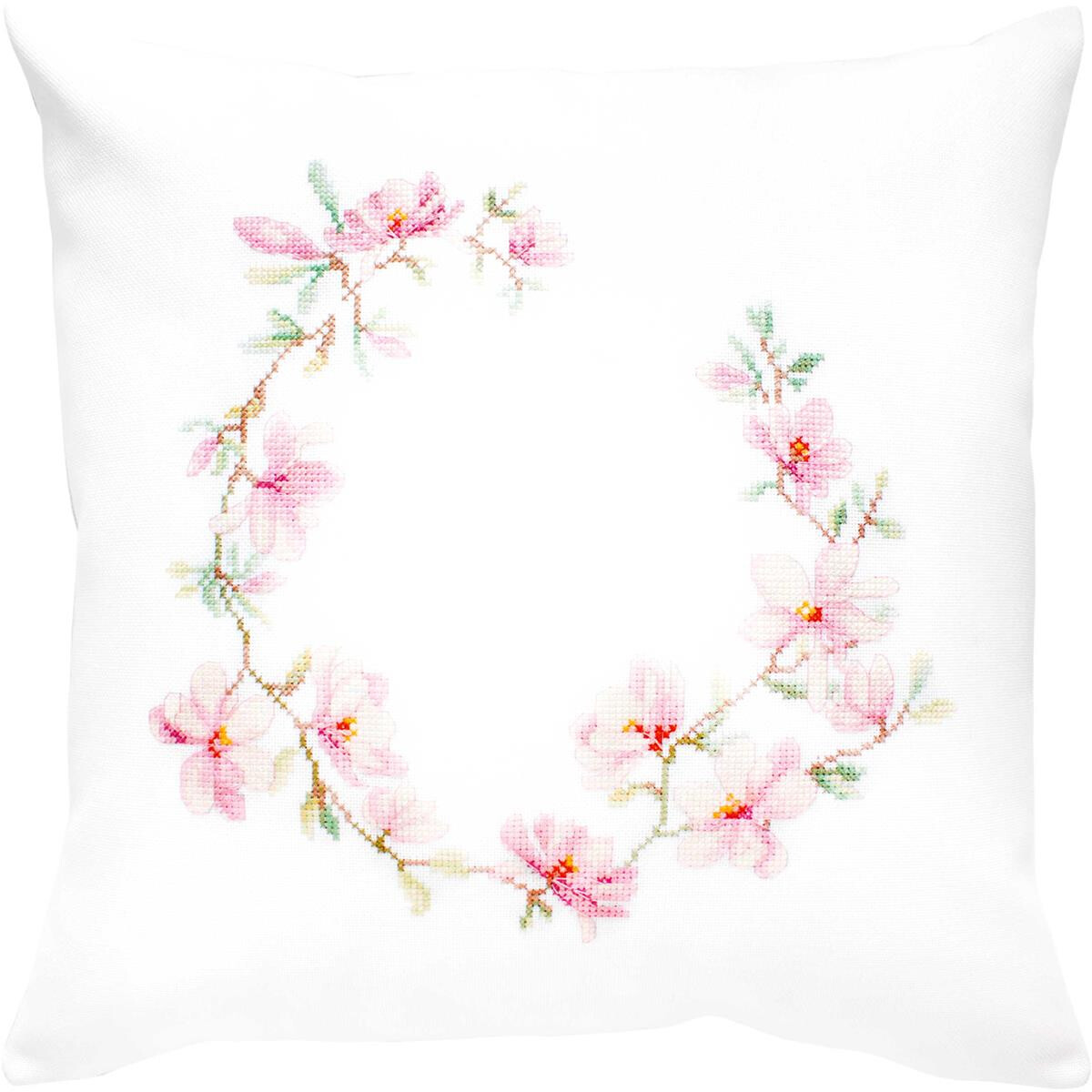 A white cushion features a delicate cross-stitch pattern...