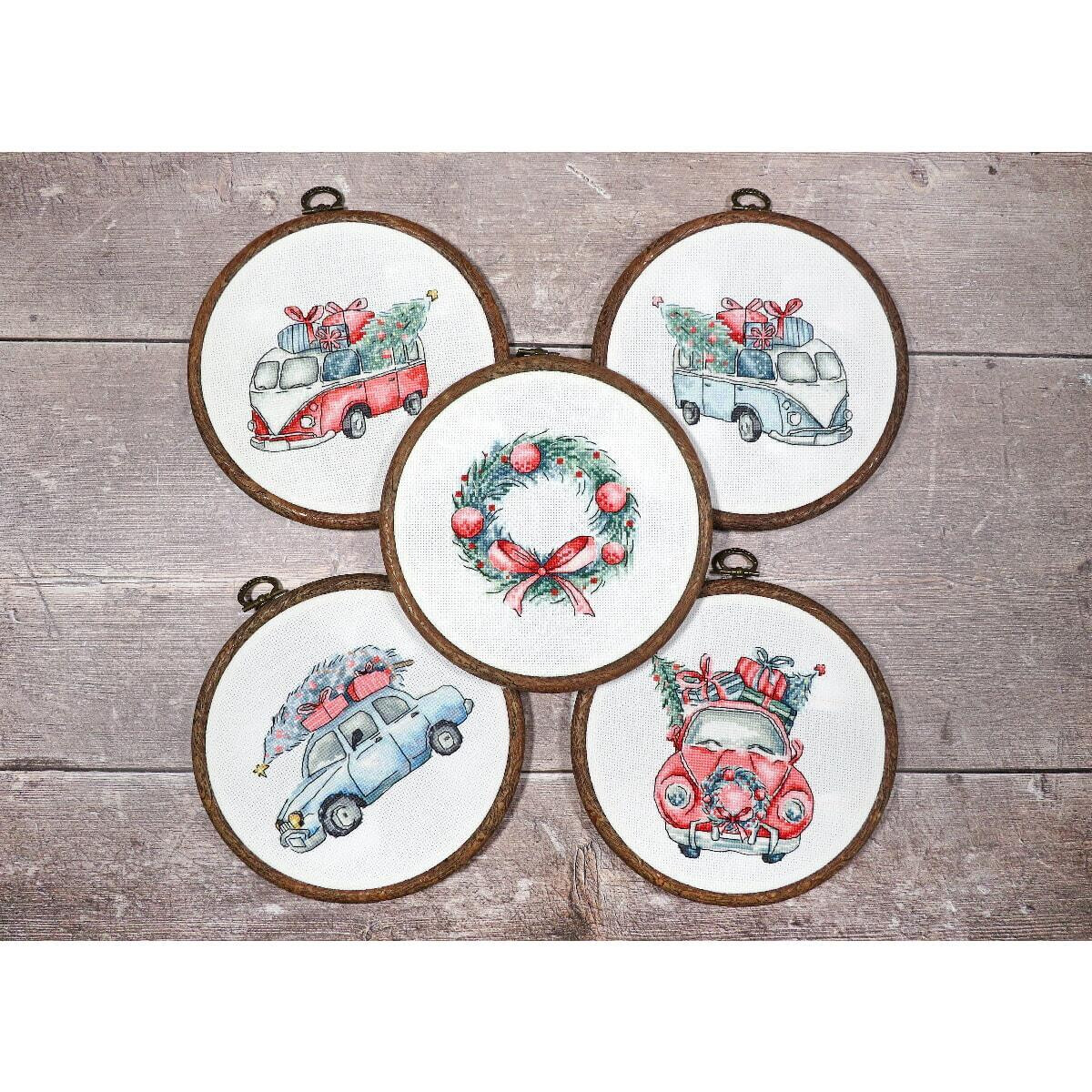 Five round embroidery frames are displayed on a wooden...