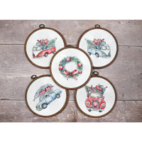 Five round embroidery frames are displayed on a wooden surface. Four frames show vintage cars decorated with Christmas presents and trees on their roofs. The middle frame, an embroidery pack by Letistitch, shows a festive wreath decorated with red bows and berries, on which two red cardinals sit.