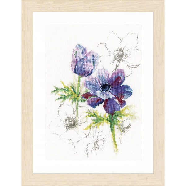 Framed artwork with purple and white anemone flowers. The central anemone is vibrant with detailed petals and a dark center. Around it are partially outlined anemones in soft lines that fade into the white background. The frame is made of light wood and complements the soft tones of this Lanarte embroidery pack piece.