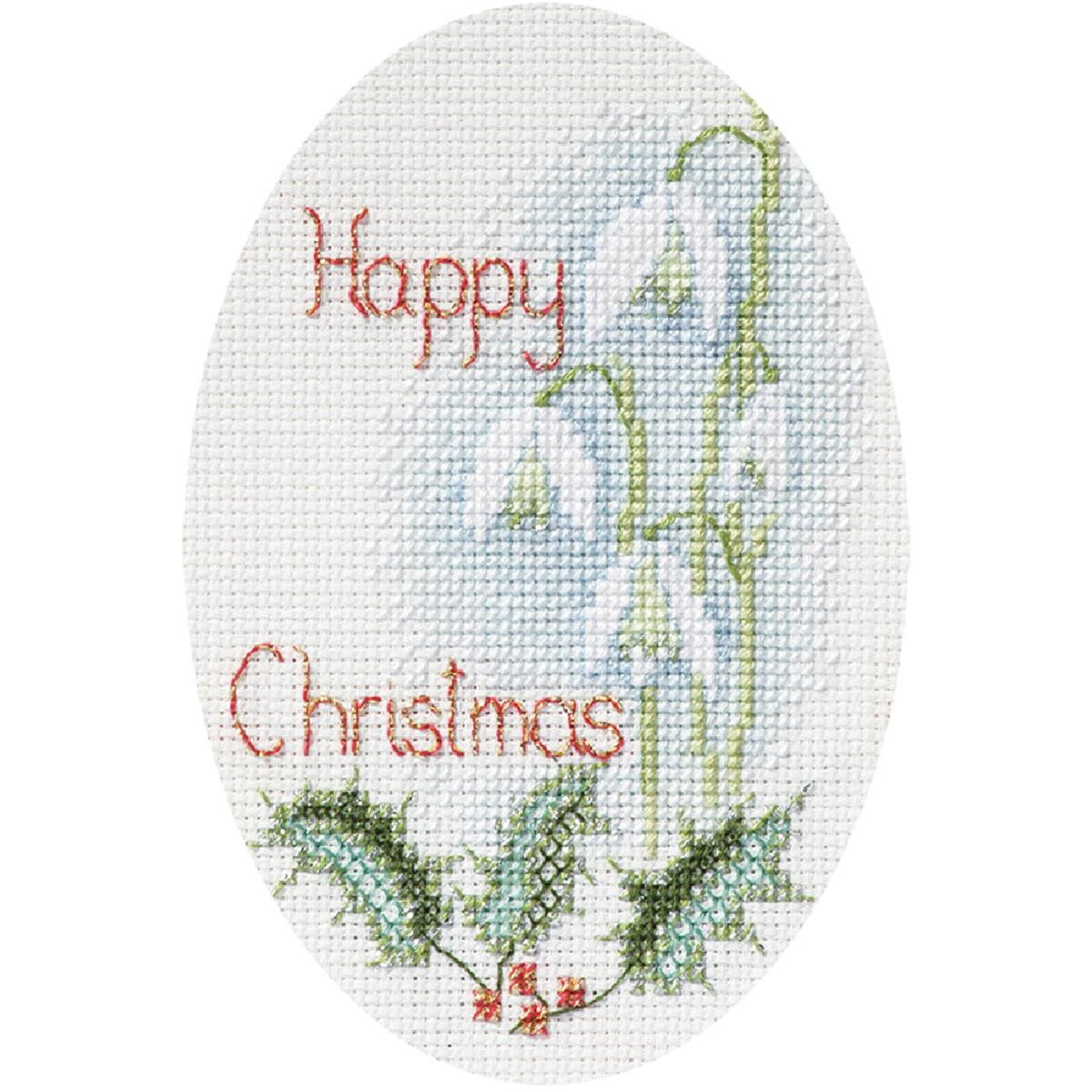 An oval cross-stitch embroidery shows the words Merry...