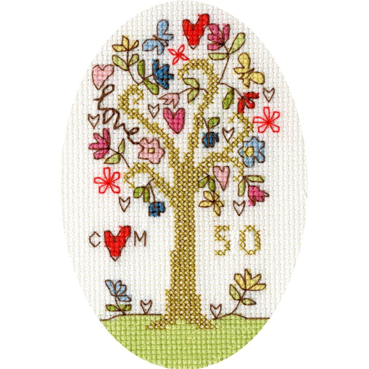 An embroidery of a tree with colorful flowers and hearts...