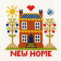 A colorful embroidery pack from Bothy Threads shows a red brick house with a blue tiled roof and an inviting yellow door. On either side are two trees with different colored leaves. Above the house are a red heart, a yellow sun and a small blue bird. NEUES ZUHAUSE (NEW HOME) is sewn underneath in red letters.