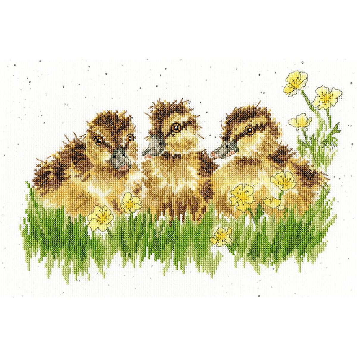 A cross-stitch depiction of three ducklings resting among...