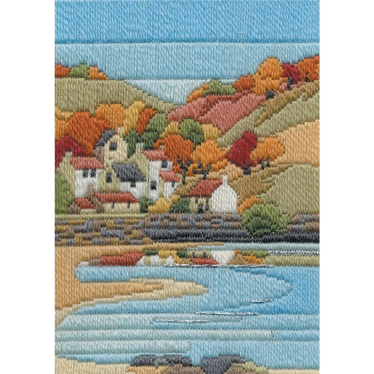 Un colorido paisaje bordado muestra un pueblo costero con...