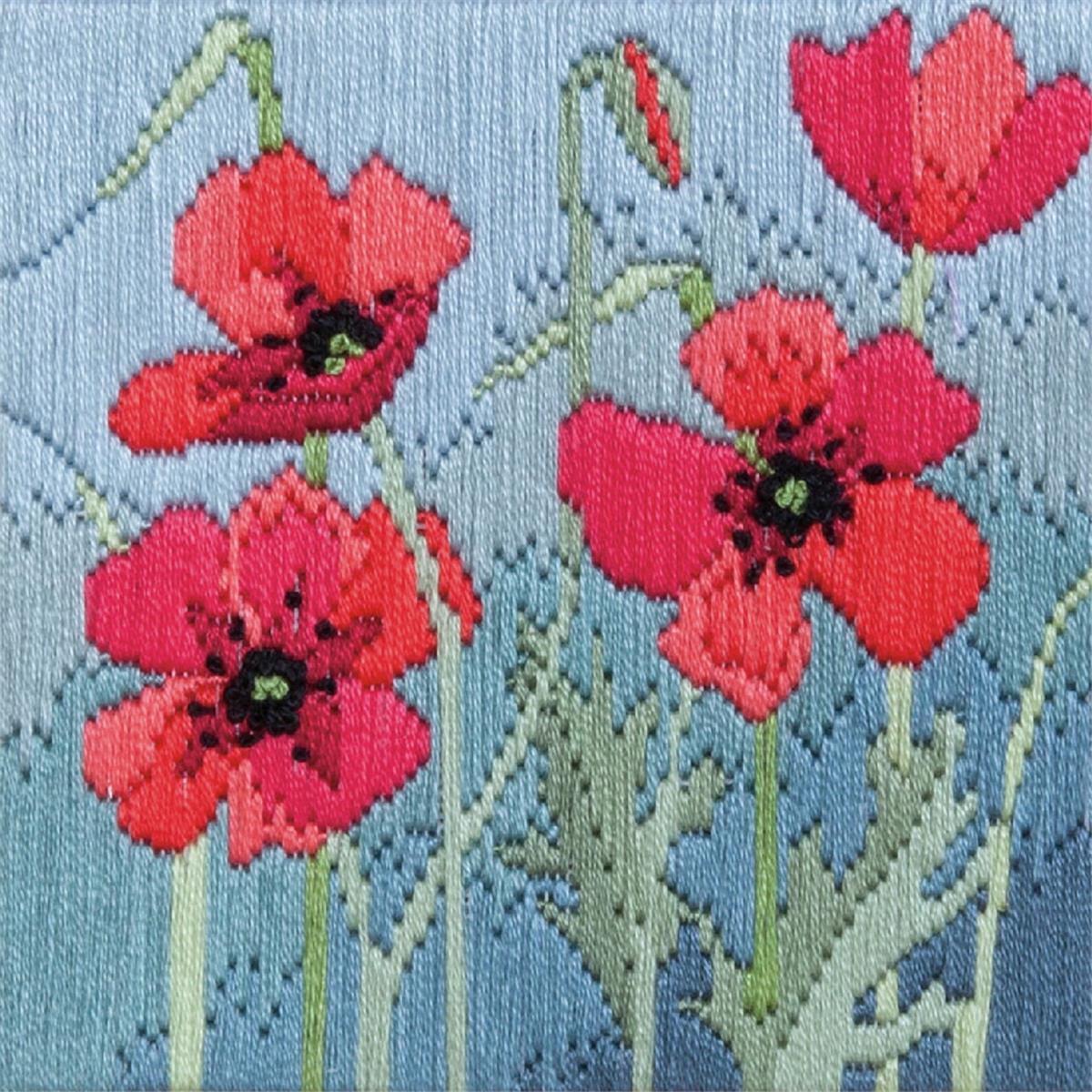 A tapestry featuring bright red and pink poppies with a...