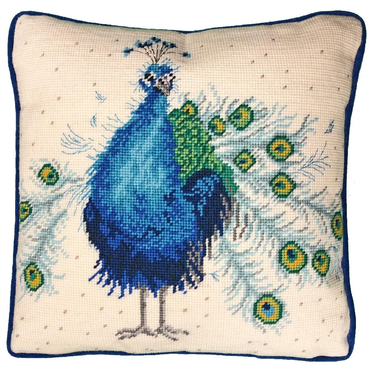 Un cuscino quadrato con un disegno a ricamo di un pavone...