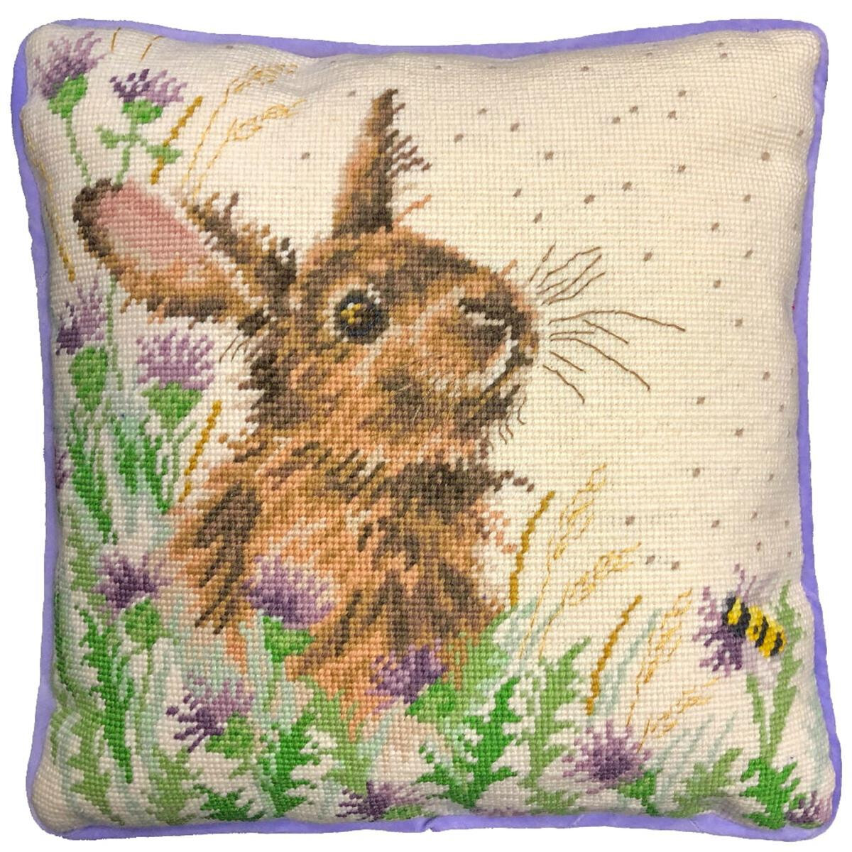 A square cushion with a hand-stitched cross-stitch...