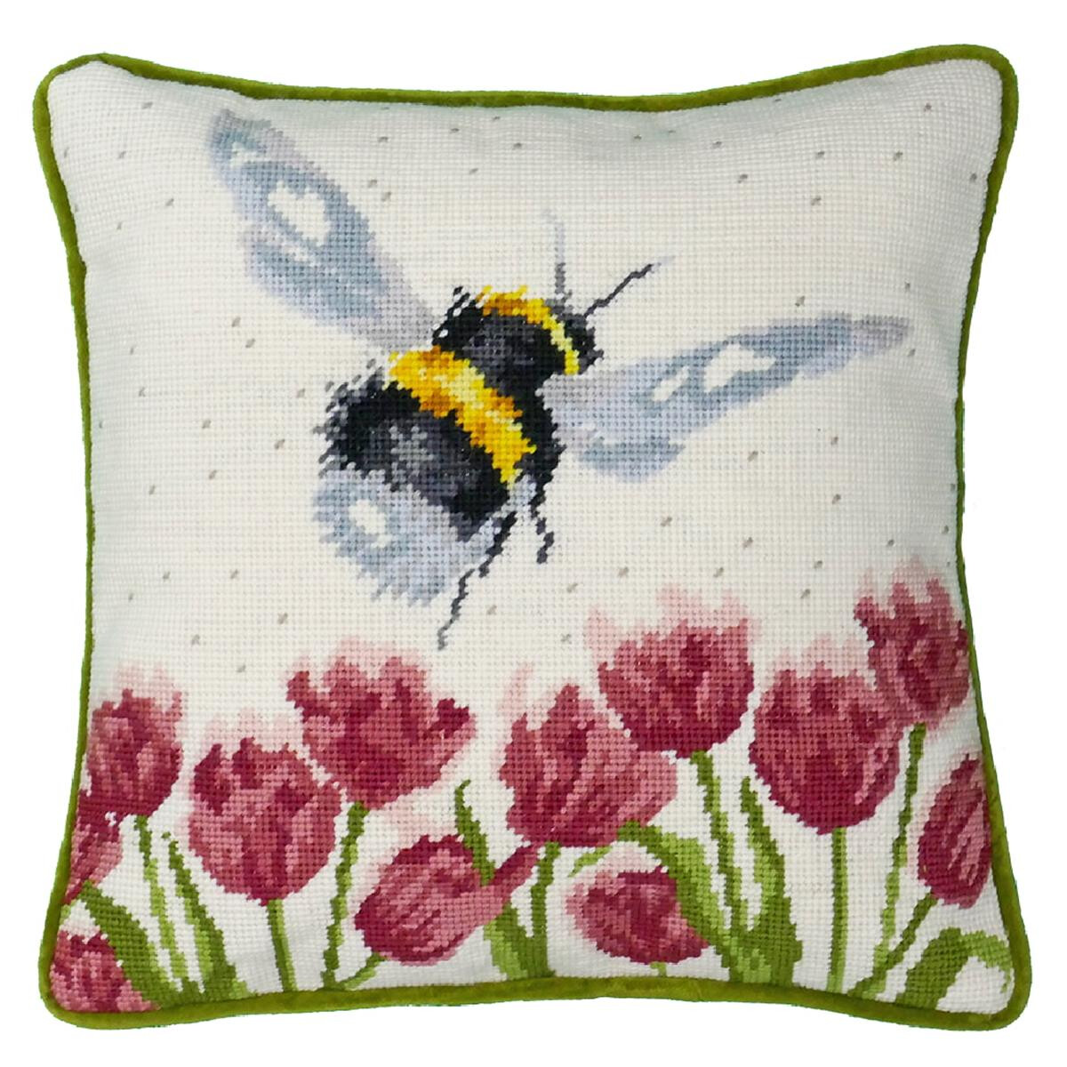 A square embroidery cushion shows a large bumblebee with...