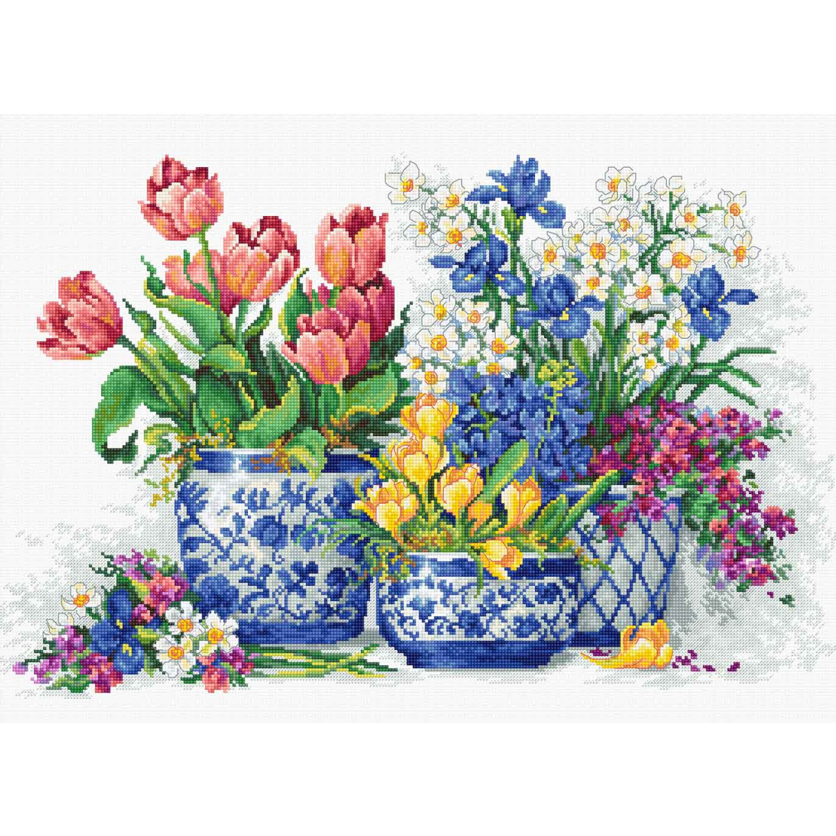 A colorful collection of flowers in blue and white vases....