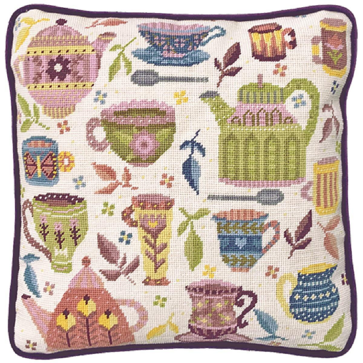 A square cushion with a whimsical tea design reminiscent...