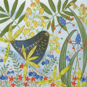 Eine Bothy Threads Stickpackung mit einem schwarzen Vogel mit goldenen Akzenten zwischen grünen Blättern, gelben Blüten, roten Sternen und blauen Knospen. Der Hintergrund ist ein helles Himmelblau, wodurch eine farbenfrohe, von der Natur inspirierte Szene entsteht.