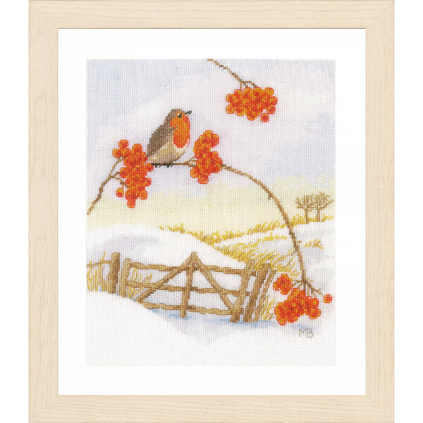 Eine gerahmte Stickpackung (Lanarte) zeigt eine Winterlandschaft mit einem Rotkehlchen, das auf einem mit roten Beeren geschmückten Ast sitzt. Darunter ist ein schneebedecktes Feld zu sehen, das von einem Holztor und einem Zaun begrenzt wird. Der Hintergrund ist in sanften Gelb- und Weißtönen gehalten und lässt eine schneebedeckte, ruhige Landschaft erahnen.