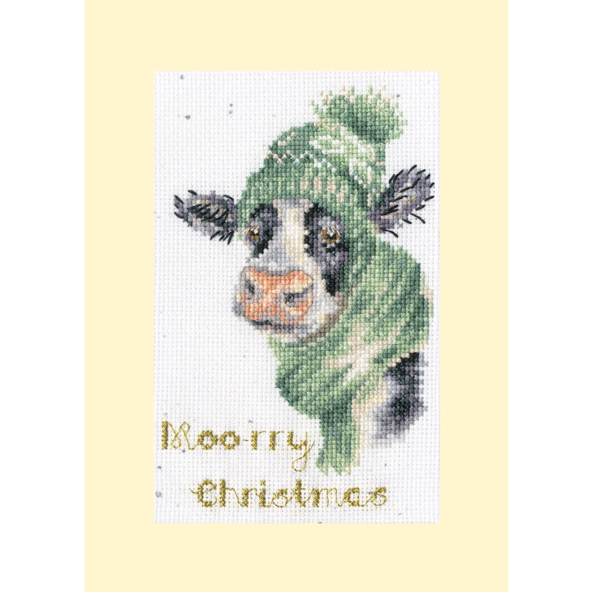 A cross stitch picture of a cow with a green knitted hat...