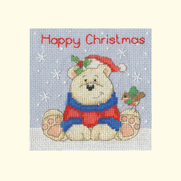 An image from Bothy Threads embroidery pack shows a smiling bear wearing a red Santa hat and a blue and red striped scarf. The bear is sitting on snow-covered ground and a robin is perched on his left paw. The words Merry Christmas can be seen above the bear in red embroidery on a light blue, snow-covered background.