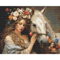 Eine heitere Frau mit langem, welligem Haar, geschmückt mit einer bunten Blumenkrone, steht neben einem weißen Pferd. Auch die Mähne des Pferdes ist mit Blumen geschmückt. Die Frau legt ihre Hand sanft auf das Gesicht des Pferdes und schafft so eine friedliche und intime Atmosphäre, die an eine zarte Luca-Stickpackung erinnert. Beide sind in dezente, erdfarbene Kleidung gehüllt.
