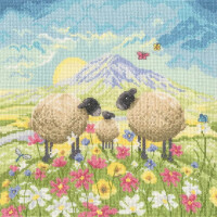 Eine pastorale Stickpackung von Bothy Threads zeigt drei Schafe – zwei größere und ein kleineres – die auf einer lebhaften Wiese voller bunter Blumen stehen. Dahinter sind sanfte Hügel und ein violetter Berg zu sehen, die von der auf- oder untergehenden Sonne beleuchtet werden, während Schmetterlinge unter einem teilweise bewölkten Himmel flattern.