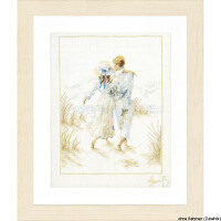 A framed embroidery pack showing a couple walking hand in hand along the beach. They are both dressed in light colored clothing, against the serene backdrop of sand dunes and ocean waves. The light-colored wooden frame and signature in the lower right corner add elegance to this piece, which reads without frame (accessories) by Lanarte.